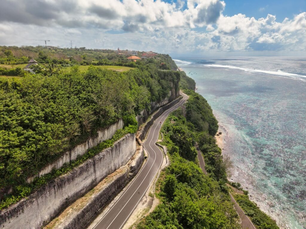 Mobil mewah berwarna hitam melaju di pantai Bali, layanan sewa mobil mewah untuk liburan eksklusif
