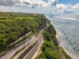 Mobil mewah berwarna hitam melaju di pantai Bali, layanan sewa mobil mewah untuk liburan eksklusif