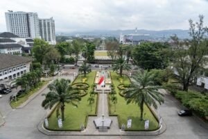 Mobil mewah terparkir di jalan Bandung, siap disewa untuk perjalanan elegan.